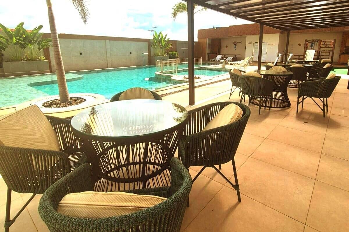 An outdoor pool area with lounge chairs and a covered seating area.