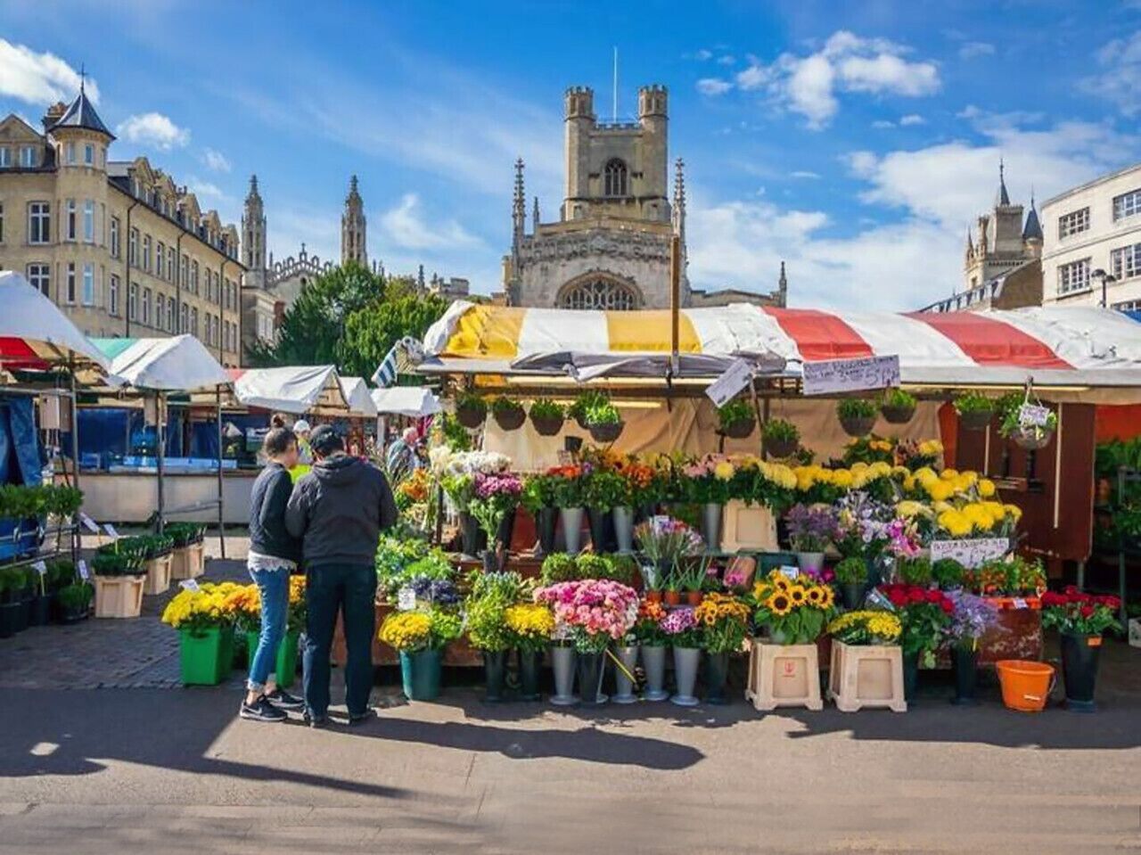 A flower market with a variety of colorful flowers displayed in pots and baskets.