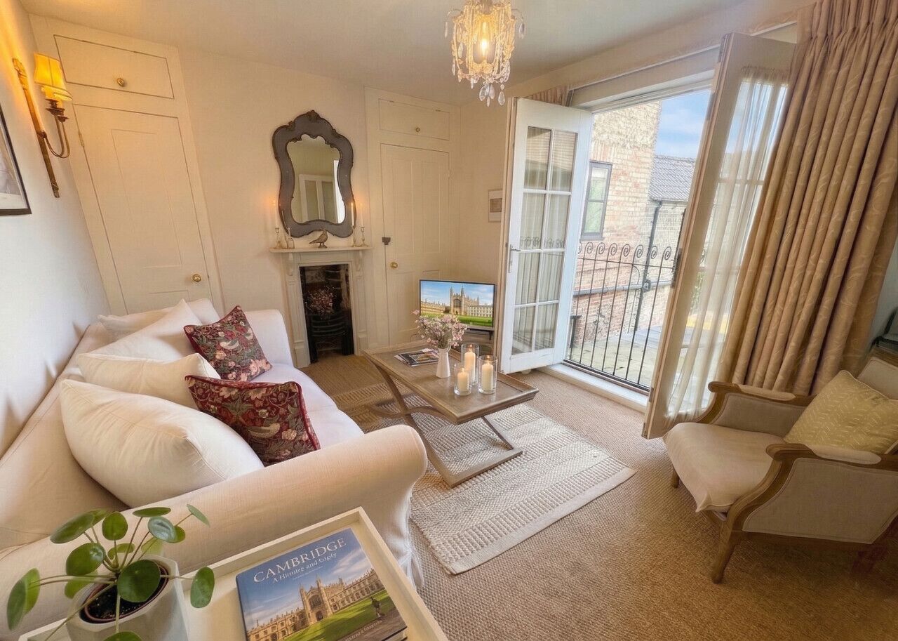 A living room with a sofa, armchair, coffee table, and a fireplace.