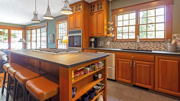 A kitchen with wooden cabinets, a large island with bar stools, a refrigerator, and a window with a view of greenery. - New Listing! Grand Getaway w/ Pool & Hot Tub (Douglas)