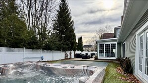 A hot tub in a backyard with a white fence, trees, and a house in the background. - New Listing! Grand Getaway w/ Pool & Hot Tub (Douglas)
