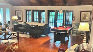 A spacious living room with a pool table, leather sofas, and a fireplace. - Refuge Home, Jacuzzi & Heated Pool 35 min Orlando. (Eustis)