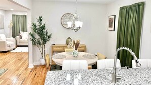 A modern dining area with a round table, chairs, and a chandelier. - Katie Mae’s Downtown Retreat (Atlanta)