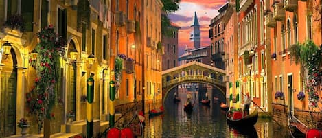 Un canale con gondole, un ponte e palazzi con balconi.