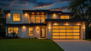 Una casa moderna de dos pisos con un garaje amplio, un balcón e ingreso bien iluminado.