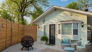A house with a covered patio, a fire pit, wicker chairs, and a wooden fence. - Spacious Cedar Park Retreat (Cedar Park)