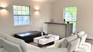 Un salon moderne avec un canapé d’angle, une table basse et un ventilateur de plafond.