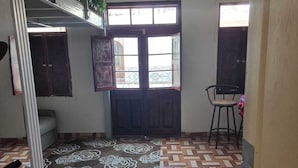 A room with a patterned floor, a large window with a view, and a chair. - In the historical center and with all services nearby. (Arequipa)