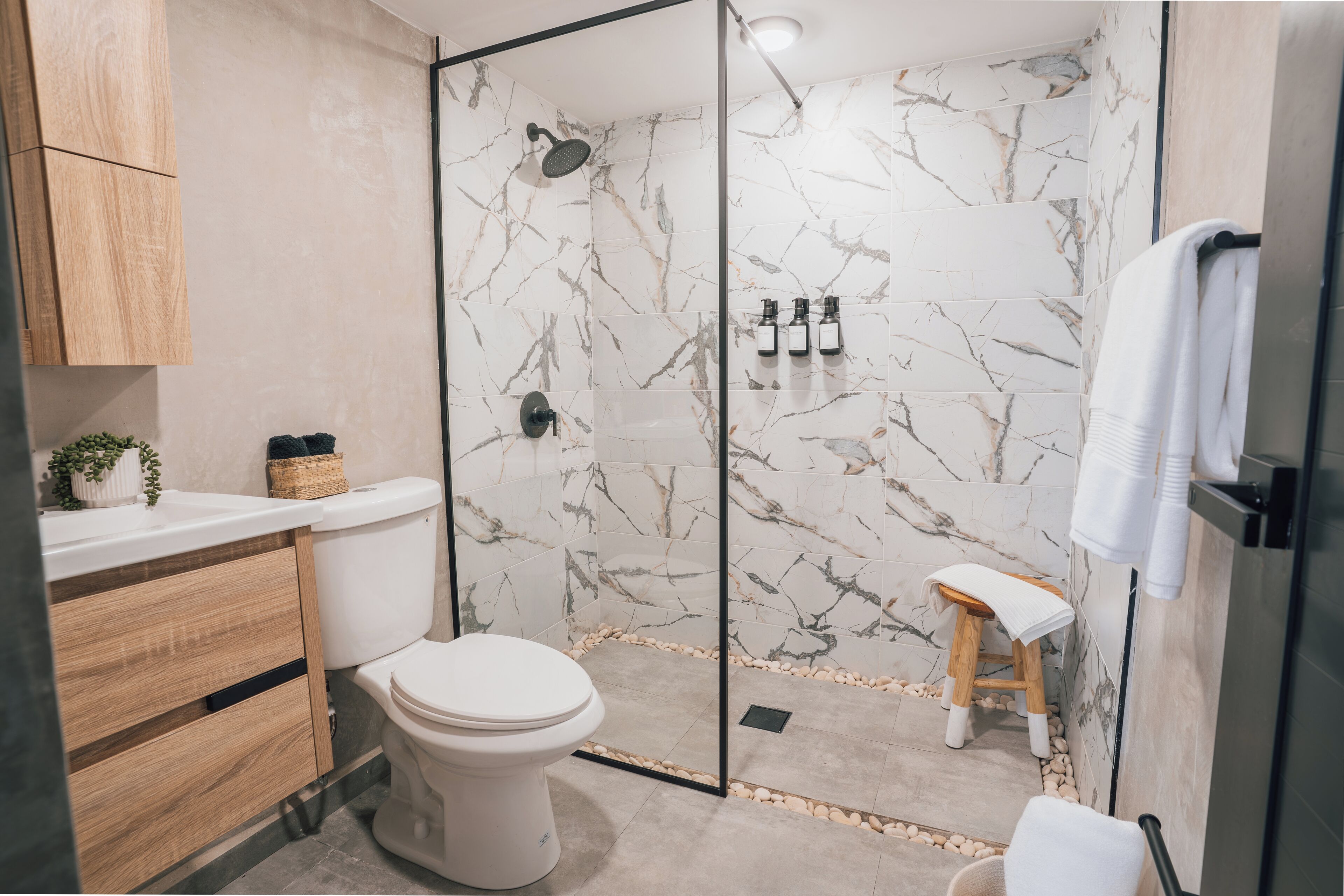Un baño moderno con inodoro, ducha y tocador de madera.