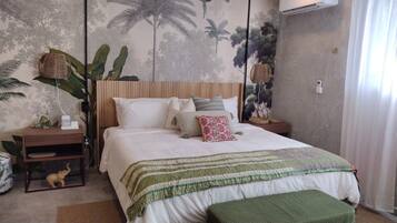 A bedroom with a bed, nightstands, a wall mural, and a window with curtains.