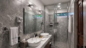 A modern bathroom with two sinks, a glass-enclosed shower, and a large mirror. - Hotel Boutique Casa Vivaldi (Mérida)