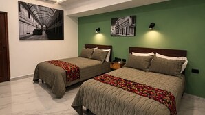 A hotel room with two beds, a ceiling fan, wall-mounted artwork, and a green accent wall. - Hotel Boutique Casa Vivaldi (Mérida)