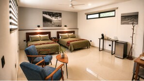 A hotel room with two beds, a desk, a chair, a small table, and a plant. - Hotel Boutique Casa Vivaldi (Mérida)