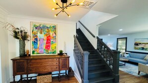 A staircase with a dark wooden handrail and black steps, leading to an upper floor. - Horton House SLEEPS 16, no pets or unapproved parties (Monroe)
