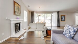 A living room with a fireplace, a sofa, a coffee table, and a dining area with chairs. - Quiet & Convenient! Santa Rosa Family Home w/ Yard (Santa Rosa)