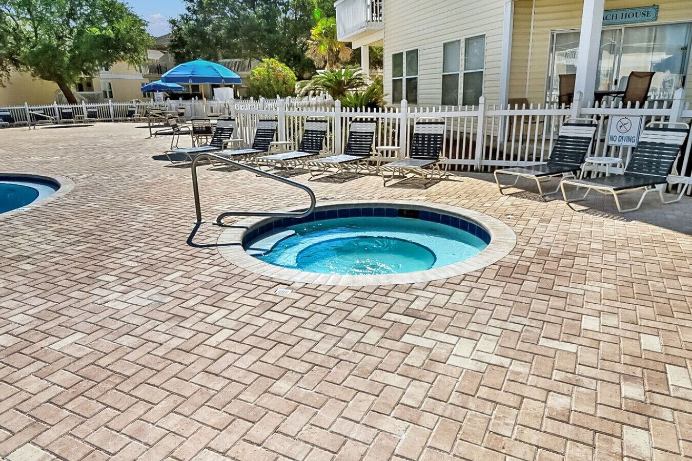 A pool area with lounge chairs and a sign indicating no diving.