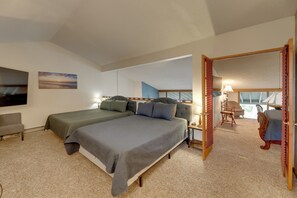Une chambre avec deux lits, un bureau, une chaise et un téléviseur.