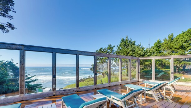 A wooden deck with lounge chairs and a glass railing overlooking the ocean. - Steps to Otter Crest Beach: Studio w/ Resort Perks (Newport)