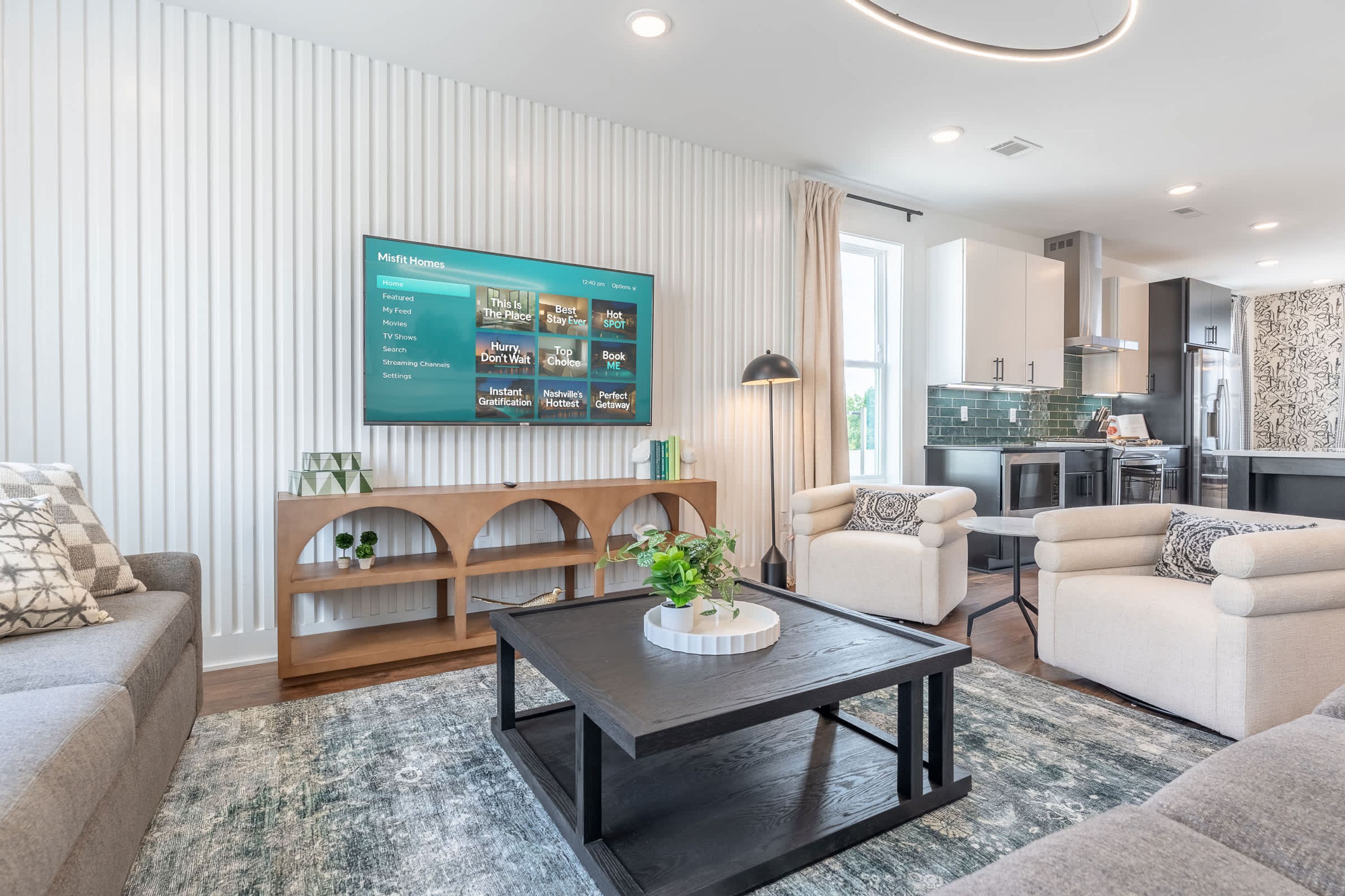 A modern living room with a flat-screen TV, a coffee table, and seating.