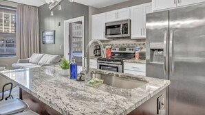 A modern kitchen with granite countertops, stainless steel appliances, and white cabinetry. - Elegant Loft in the Heart of Downtown / Gym (Cleveland)
