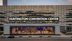 Das äußere Erscheinungsbild des Huntington Convention Centers mit modernem Design, das eine große Glasfassade und ein Schild zeigt, das anzeigt, dass es eine 2-minütige Fahrt von Cleveland entfernt ist.