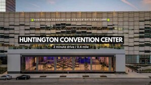 Das äußere Erscheinungsbild des Huntington Convention Centers mit moderner Architektur, darunter eine große Glasfassade und ein Schild, das anzeigt, dass es eine 2-minütige Fahrt von Cleveland entfernt liegt.