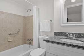 A modern bathroom with a bathtub, toilet, and sink.