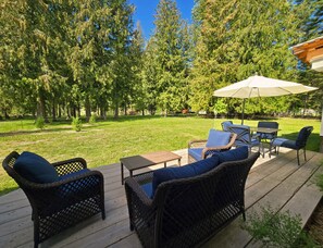 A patio with wicker furniture, a table, and an umbrella.