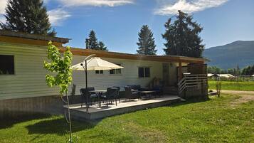 A mobile home with a patio, outdoor furniture, and a view of the surrounding landscape.
