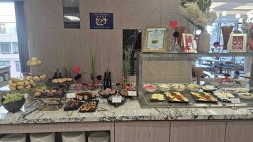 A buffet counter with various food items, a sign indicating a restaurant, and a certificate on display.