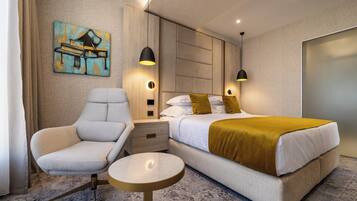 Una camera d'albergo moderna con un letto, una sedia, un comodino e un quadro appeso al muro.
