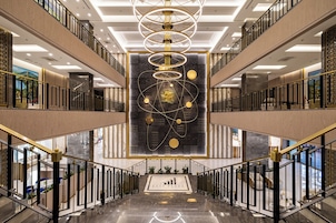 A modern interior with a central art installation, multiple floors, and a prominent staircase.