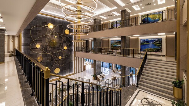 Eine mehrstöckige Hotelhalle mit einem prächtigen Kronleuchter, Marmorböden und einem großzügigen Sitzbereich.