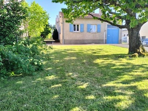 A residential area with a house, a tree, and a blue door.