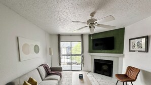 A modern living room with a sofa, a coffee table, a fireplace, and a television. - Sleepover | Peaceful 1BD/1BA + Gym - Austin TX (Austin)