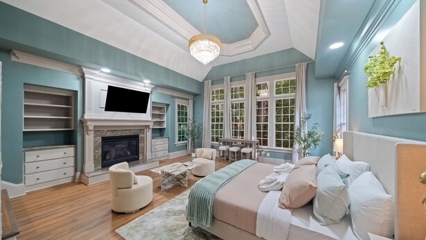 A bedroom with a fireplace, a bed, a desk, and a chair.