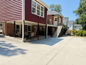 Een tweelaags huis met een overdekte patio en een trap naar de tweede verdieping.