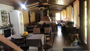 Een landelijke keuken met een eethoek, houten plafond en bakstenen muren.