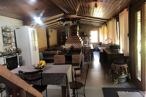 A rustic kitchen with a dining area, wooden ceiling, and brick walls. - Sítio Solar di Stella (Itatiaia)