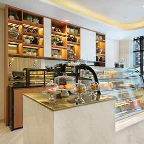Un comptoir de boulangerie avec des pâtisseries et une machine à café.