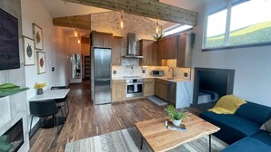 Une cuisine moderne avec des meubles en bois, un réfrigérateur en acier inoxydable et un four à micro-ondes encastré.