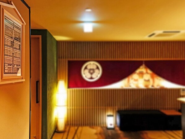 A room with a traditional Japanese aesthetic, featuring a tatami mat floor, a shoji screen, and a low table.
