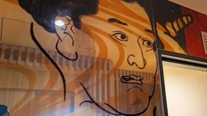 A wall with a mural of a person.