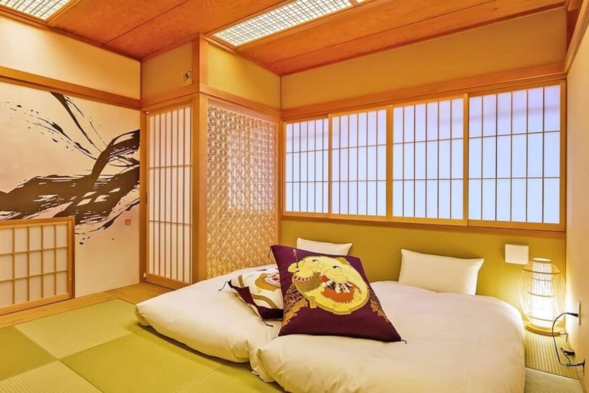 Ein traditioneller japanischer Raum mit Tatami-Böden, Shoji-Schirmen und einem großen Wandbild.