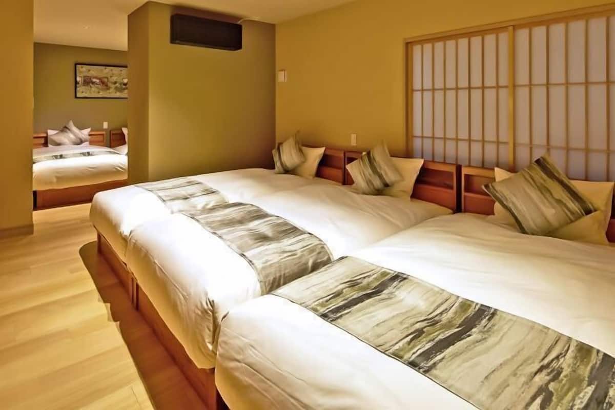 Ein Hotelzimmer mit einem großen Bett, einem hölzernen Kopfteil und einem Shoji-Bildschirm.