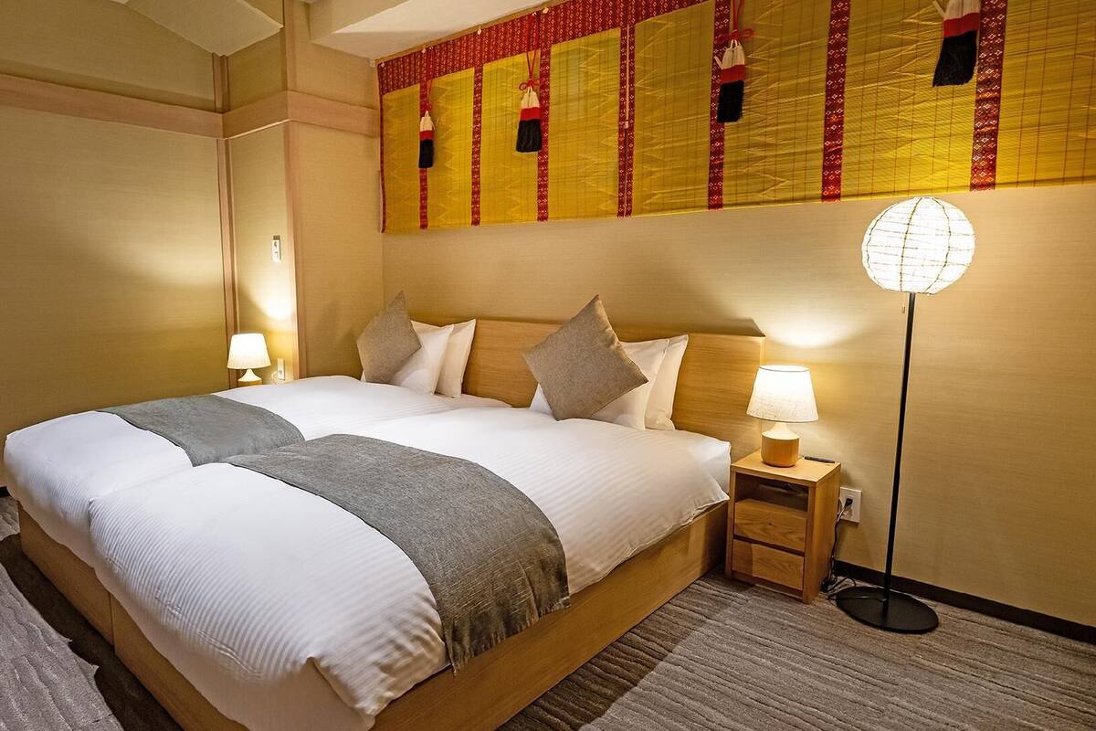 Ein Hotelzimmer mit einem großen Bett, Nachttischlampen, einer Stehlampe und einer dekorativen Wandverkleidung.