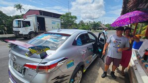 A silver car with decals and a large rear spoiler parked at a roadside stall. - Red Uakari Jungle Lodge (Iquitos)