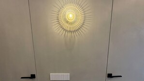 Una habitación moderna con una lámpara de techo original, un termostato y una manija de puerta.
