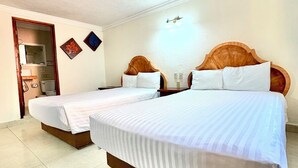 A hotel room with two beds, a mirror, a wall-mounted light, and a door leading to a bathroom. - Charming Room Near Artisan Shops – Great Choice for Exploring Cancún | 4 Units (Cancun)