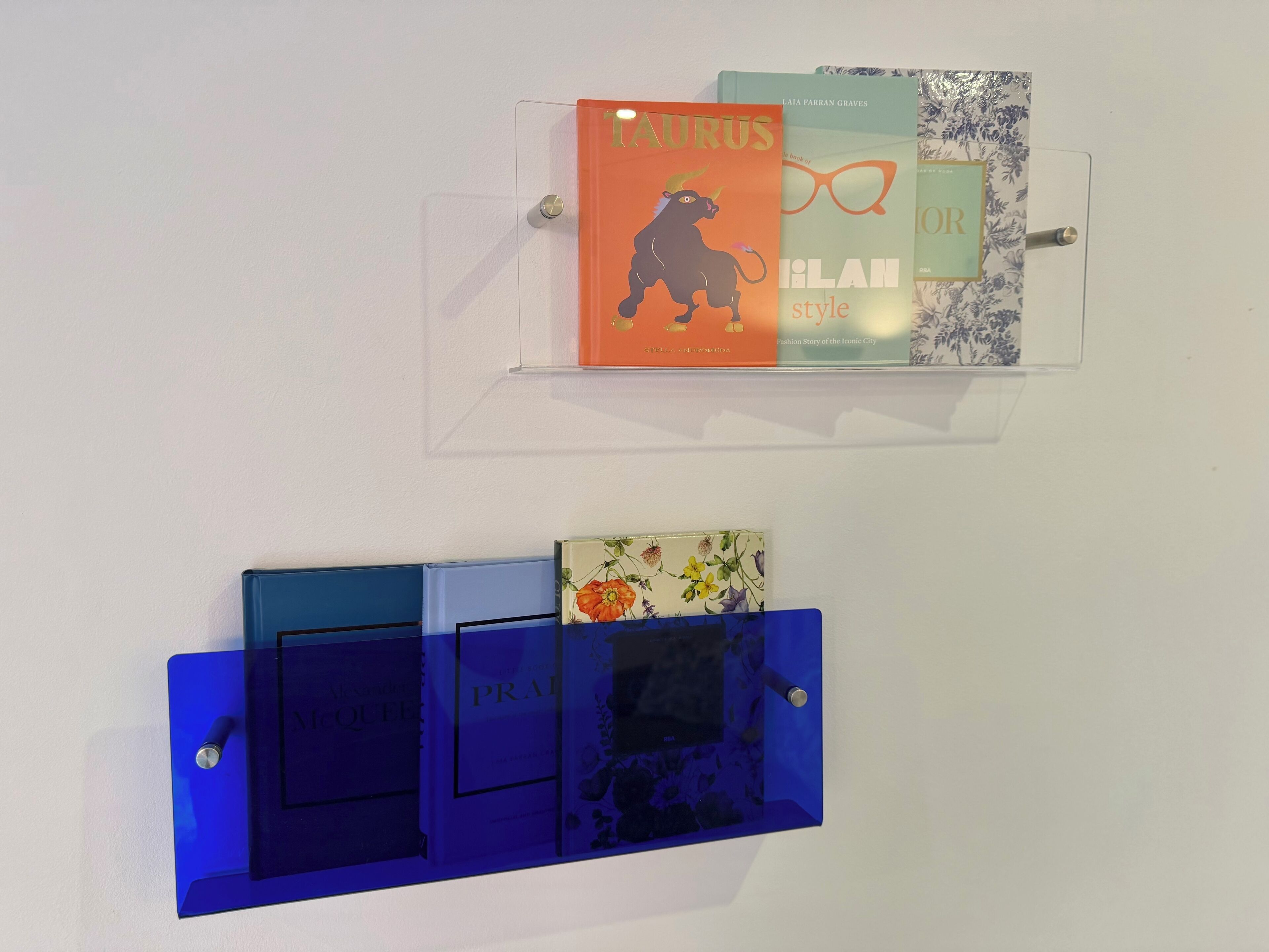 Deux panneaux d’affichage fixés au mur, ornés de livres et d’objets décoratifs.